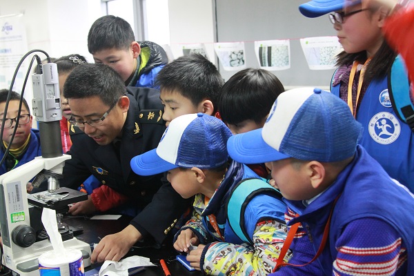 嘉兴市出入境检验检疫局工作人员手把手教授新华小记者如何使用显微镜.JPG