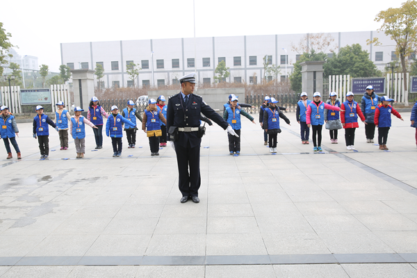 图为交警带领新华小记者学习交通指挥手势.png