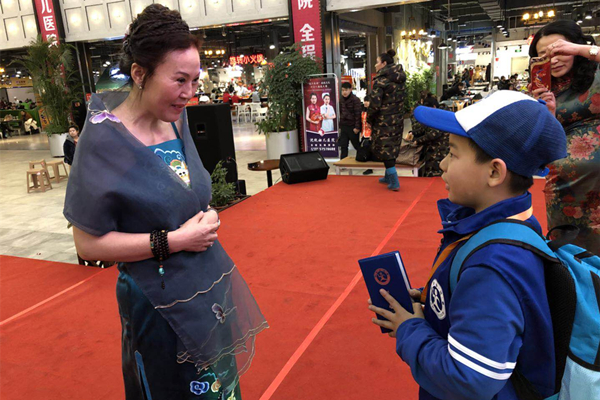 1517562202812095.jpg 图为抚顺市旗袍协会会长赵桂英接受新华小记者何昕暘采访.jpg